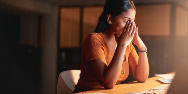 Woman holding her head in pain due to headache from TMJ in New Jersey