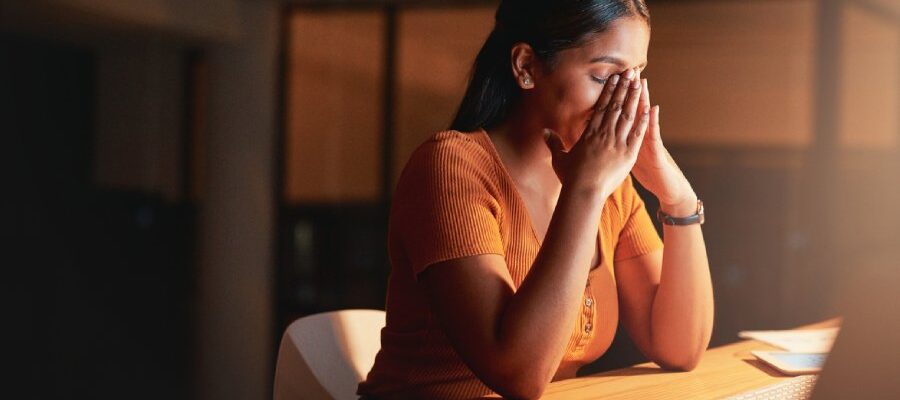 Woman holding her head in pain due to headache from TMJ in New Jersey